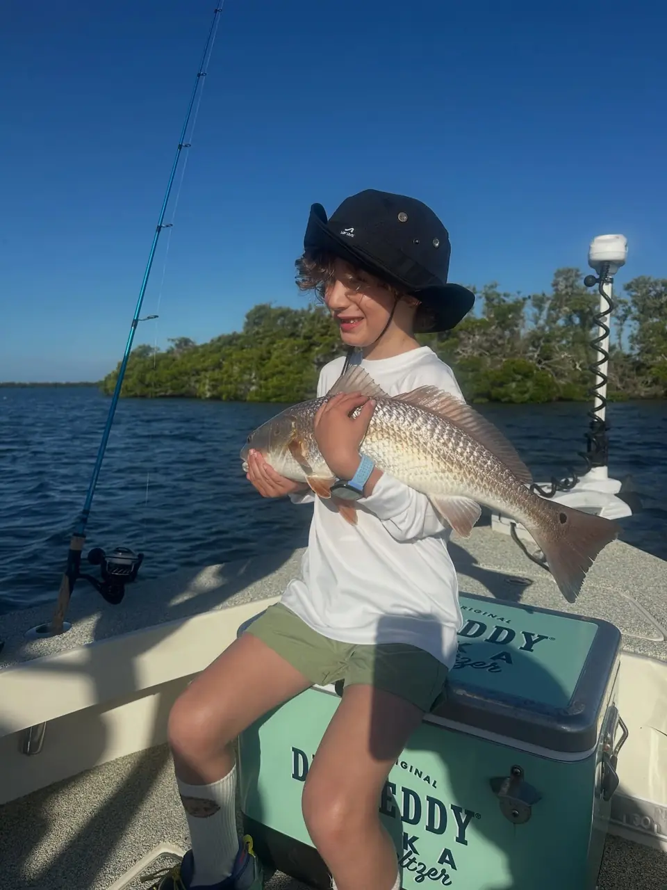 Young angler holding a redfish on a family fishing charter in Tampa Bay with Big Daddy Sportfishing.